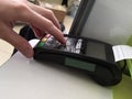 The sellerÃ¢â¬â¢s hand uses a cashless payment terminal